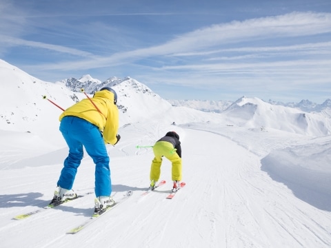 Skifahrer fahren auf der Piste nach unten