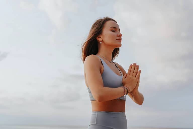 Ein Frau faltet die Hände beim meditieren